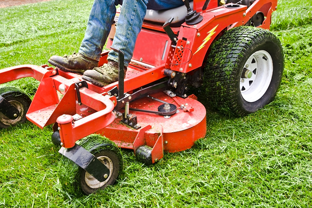 7381362_l Man on a riding lawn mower that has grass stuck to the wheels. spring and summer outdoor maintenance.